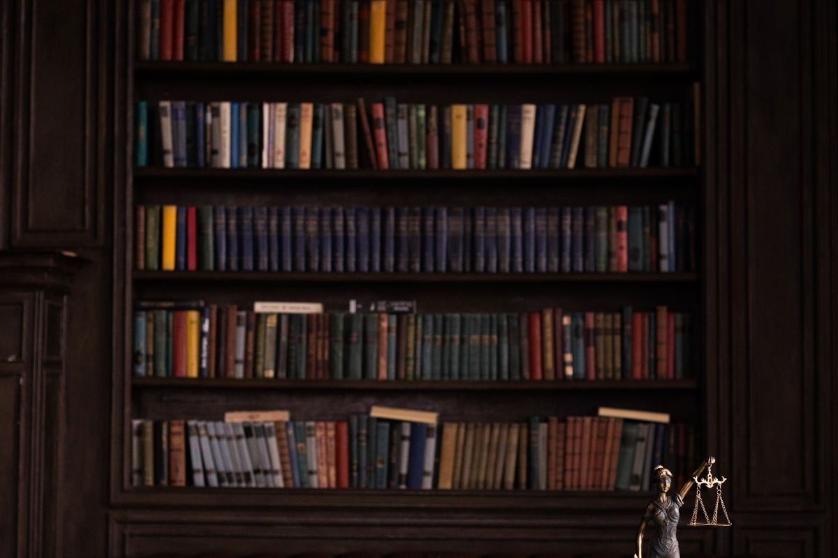 Law library bookshelves with a scales of justice figure